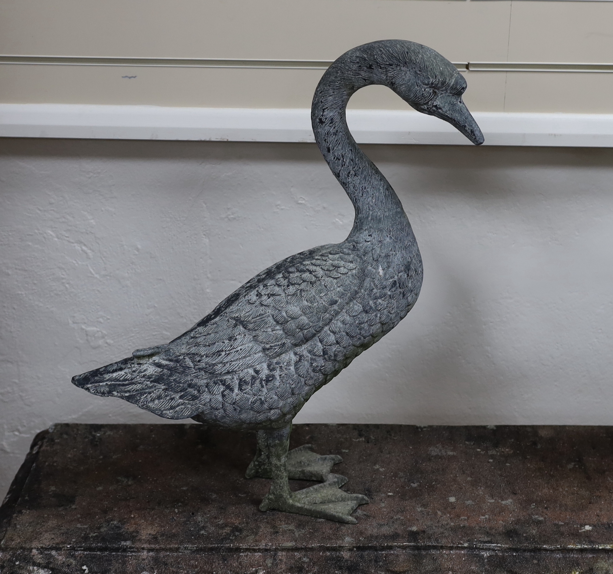A pair of cast metal garden ornaments modelled as geese, larger height 71cm